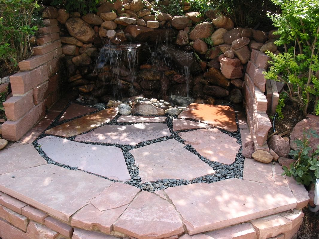 Flagstone patio facing a rock waterfall