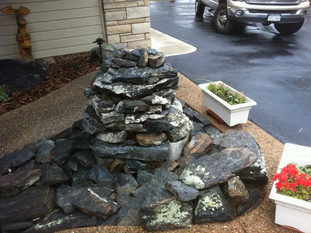 Stacked stone water feature beside a home entry